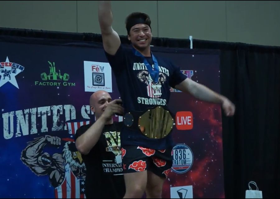 Alex Huang winning a United States Strongest Man competition with the championship belt